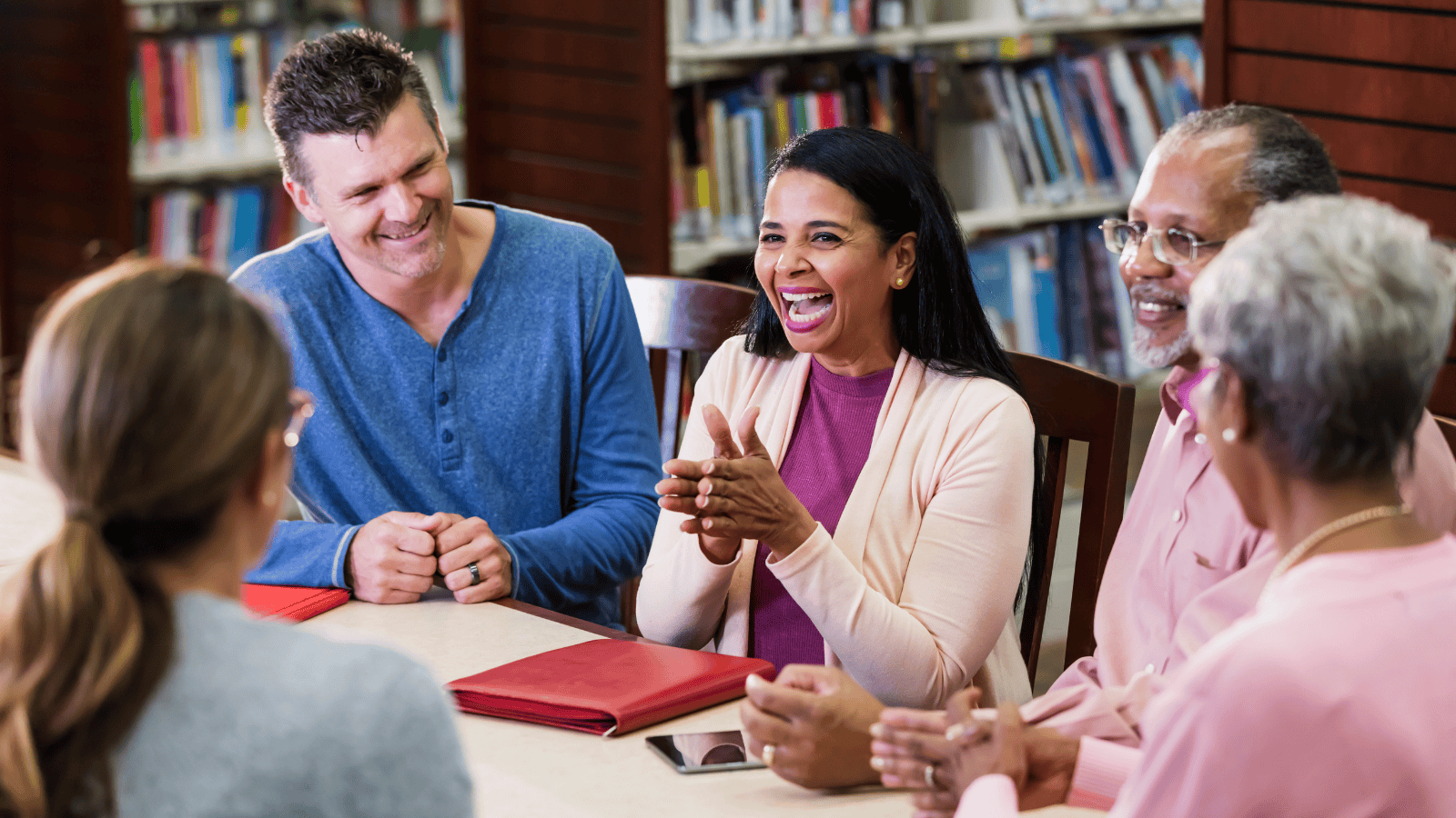 Group of adults attending a seminar with an educator in a library